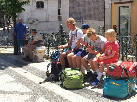 The boys, snarfing sandwiches in the Camões Square, in Lisbon, after arriving by bus.
