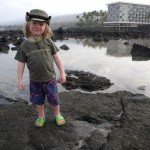 Finis, our 2-year-old, poses on a rock in the ocean tidepools. That's the Outrigger Keauhou Beach Resort in the background.