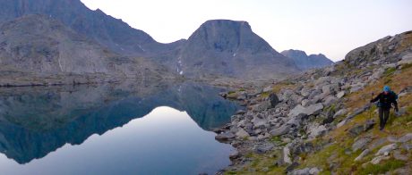 Kathy, scrambling over some rocks and tundra during early morning reflections in one of the lakes of Indian Basin.